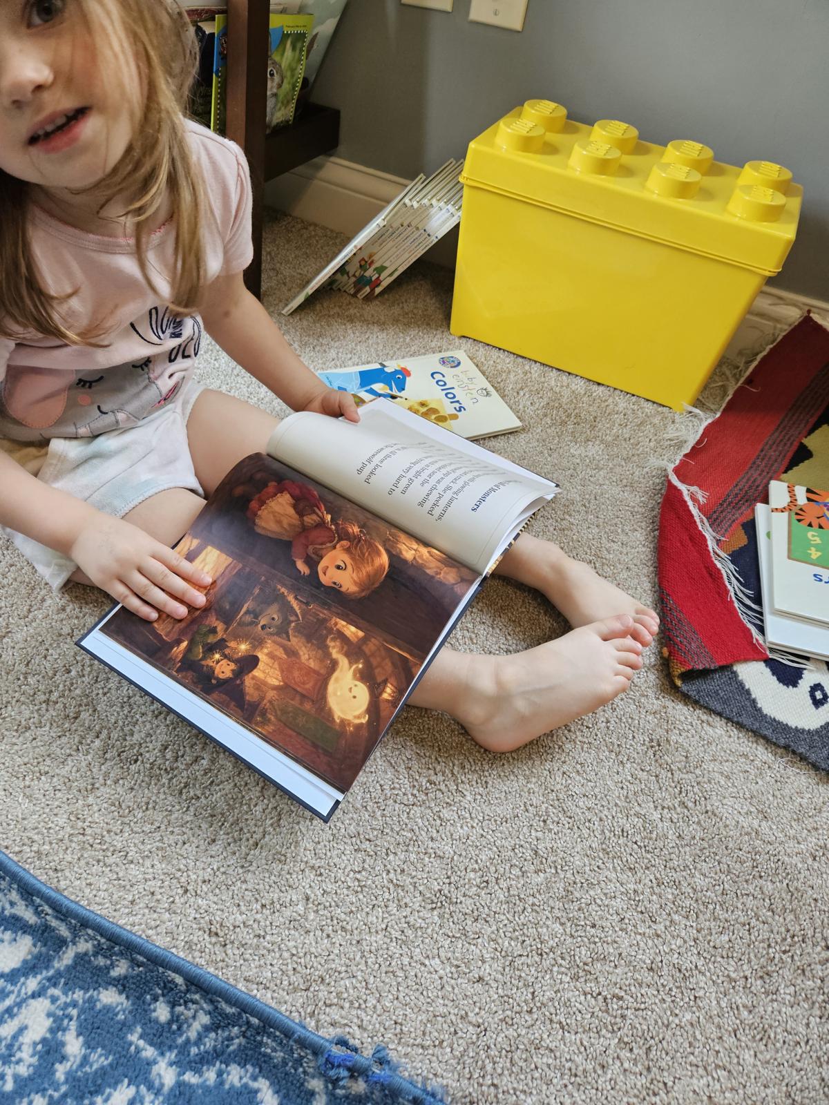 A child sitting on the floor reading a PageCub personalized storybook