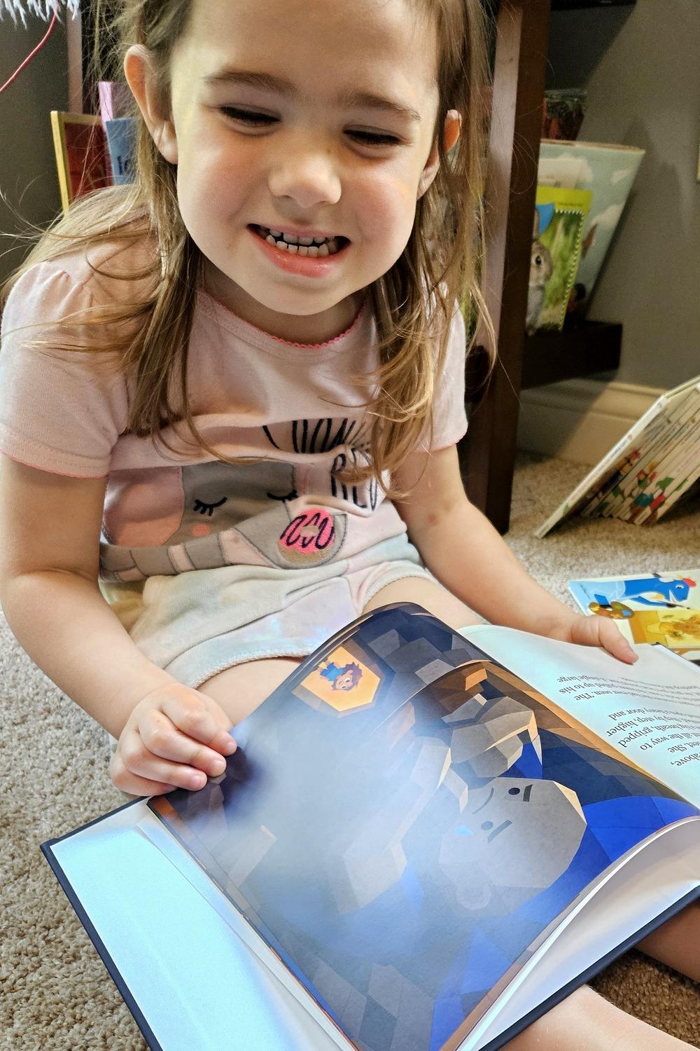 A child beaming at her personalized PageCub storybook